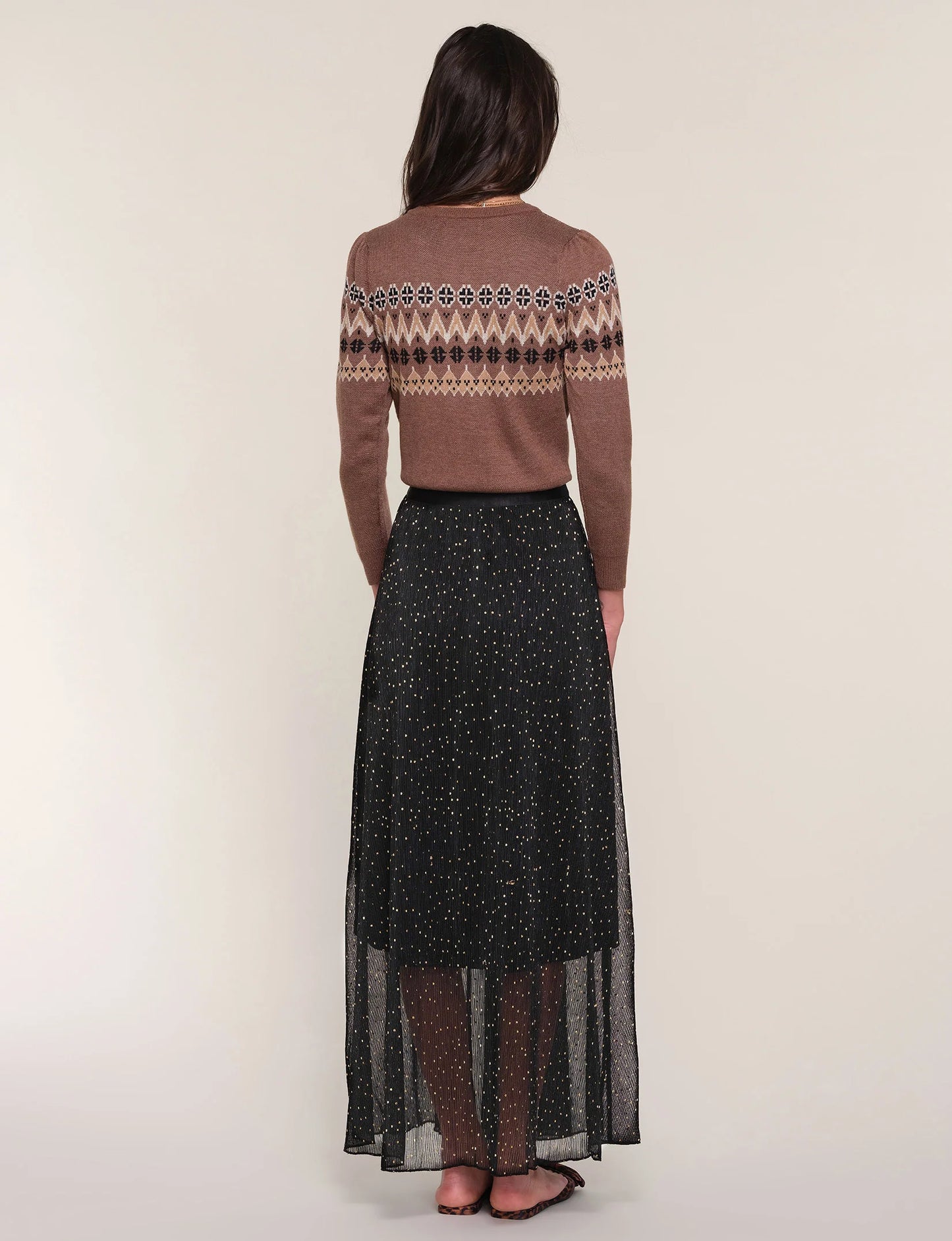 simple maxi skirt with an elastic waist. It showcases a sheer crinkled fabric with a delicate foil print throughout.