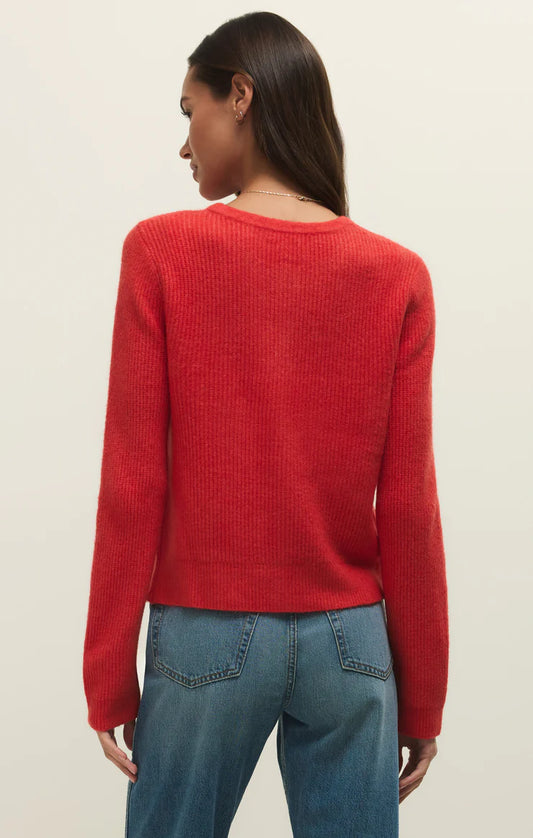 Back view of a woman wearing a red relaxed button up crewneck rib cardigan