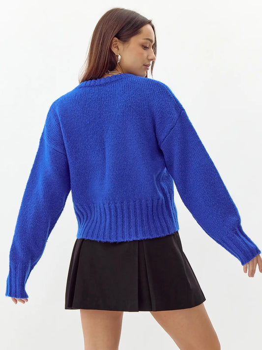 Back view of a woman wearing a blue sweater 