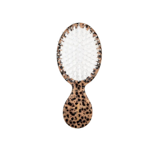 Hairbrush with leopard print handle on a white background