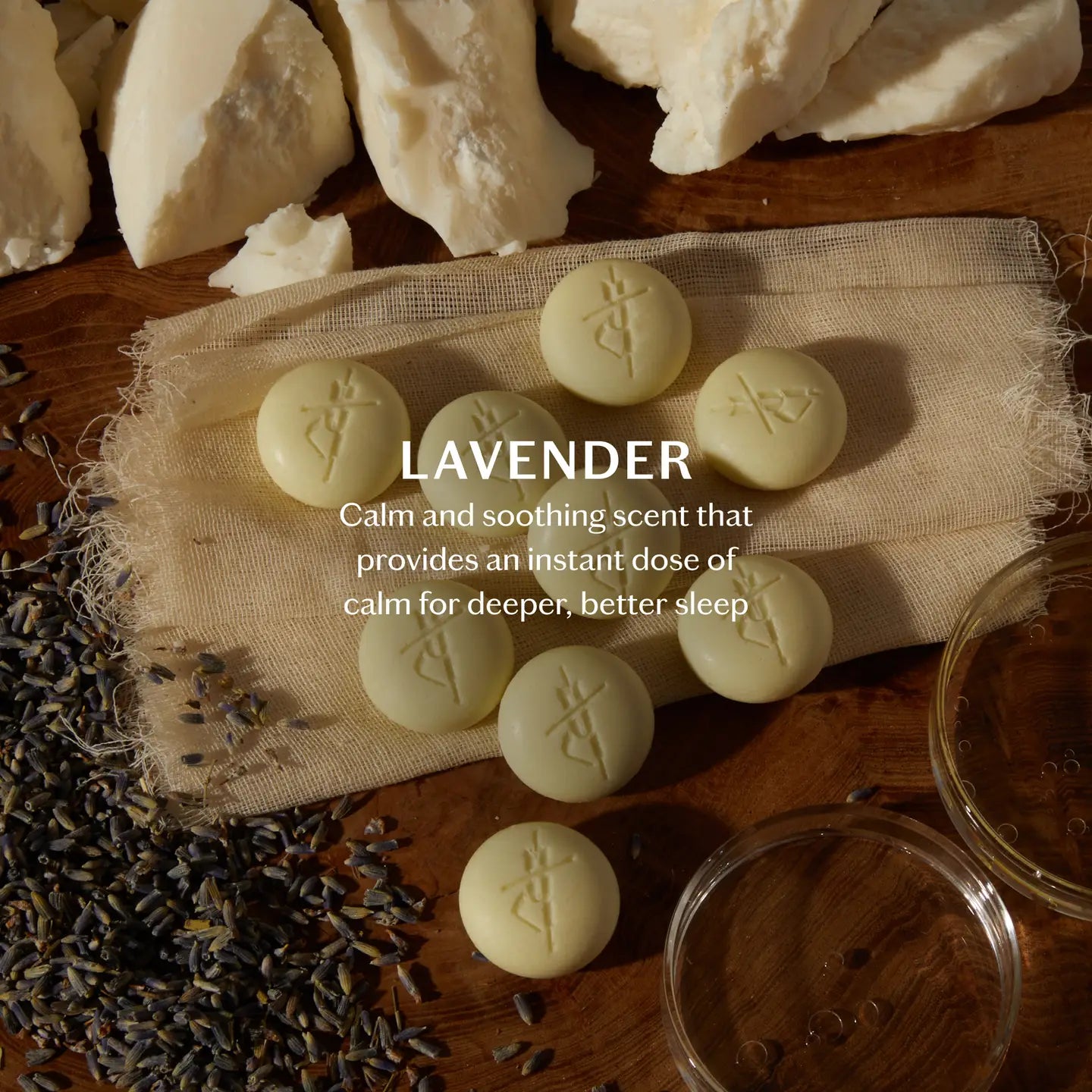 Lavender-scented bath pebbles on a wooden surface with lavender flowers and a jar, labeled 'Calm and soothing scent that provides an instant dose of calm for deeper, better sleep'.