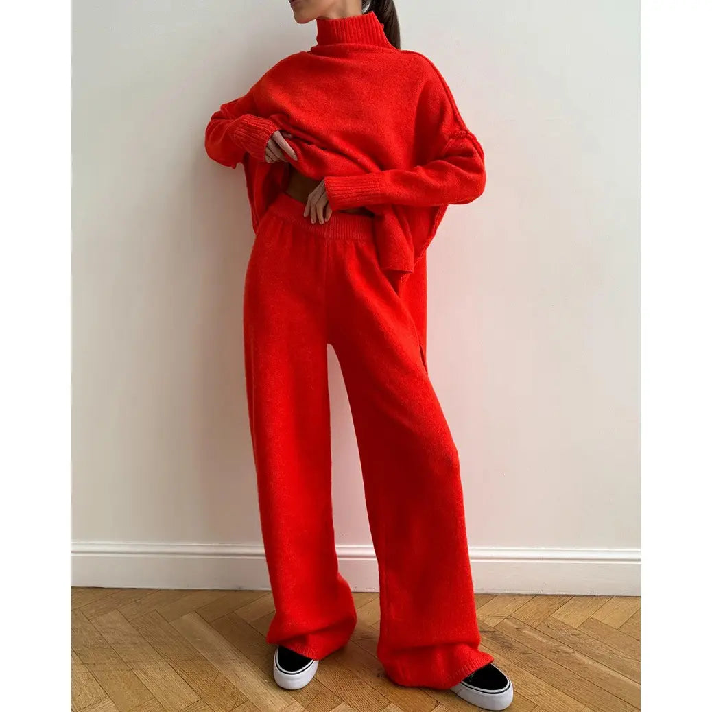 Woman wearing a lounge set in tomato red includes a soft turtleneck sweater paired with relaxed, flared pants for effortless comfort