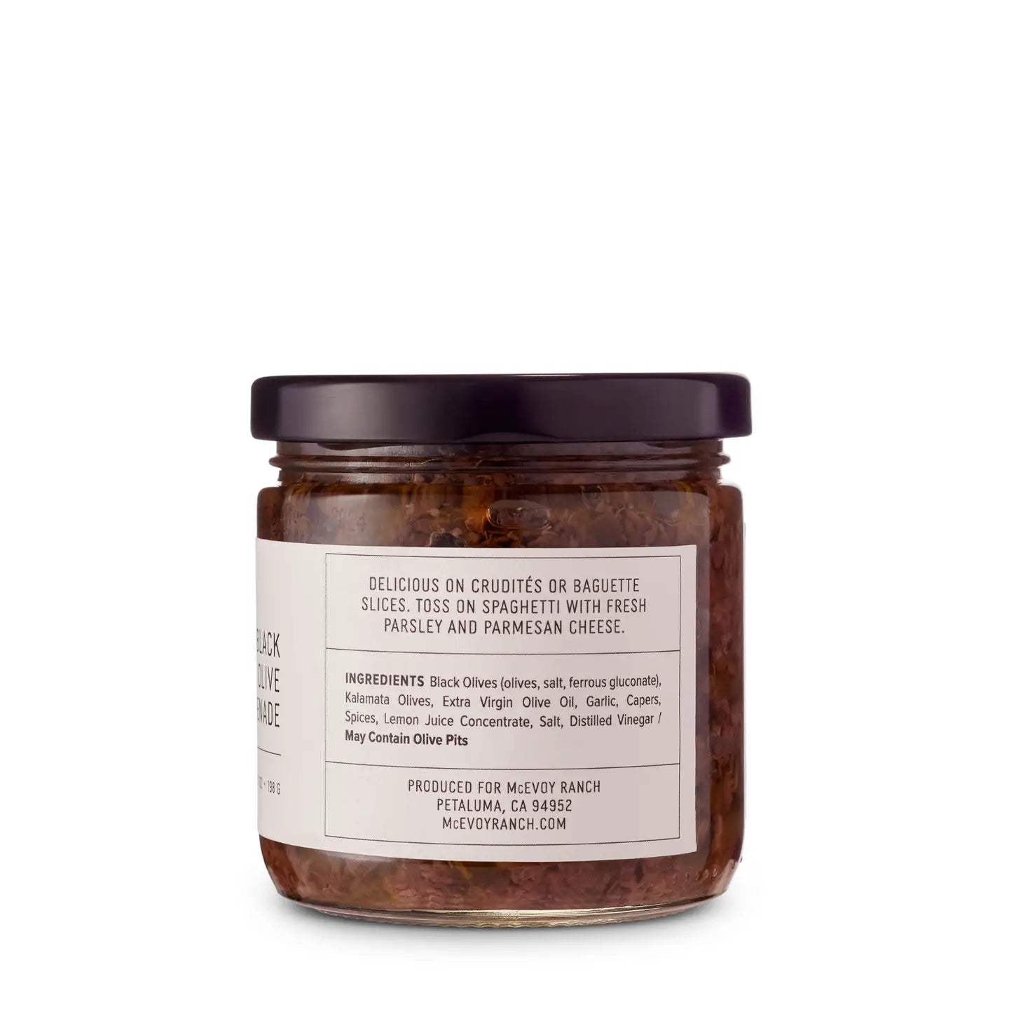 Jar of black olive tapenade with ingredientlabel on a white background