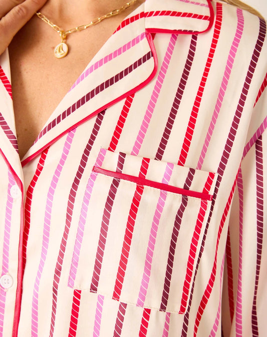 Close-up of a person wearing a striped pajama top with pink and red lines.
