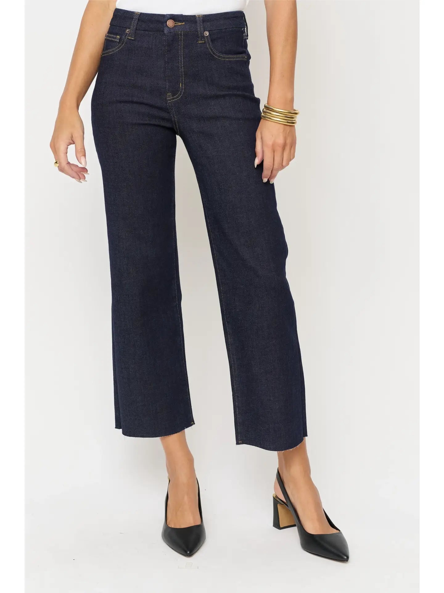 High-rise denim wide leg crop, fitted through the hip, zipper fly, and a cropped raw hem. Close up view.