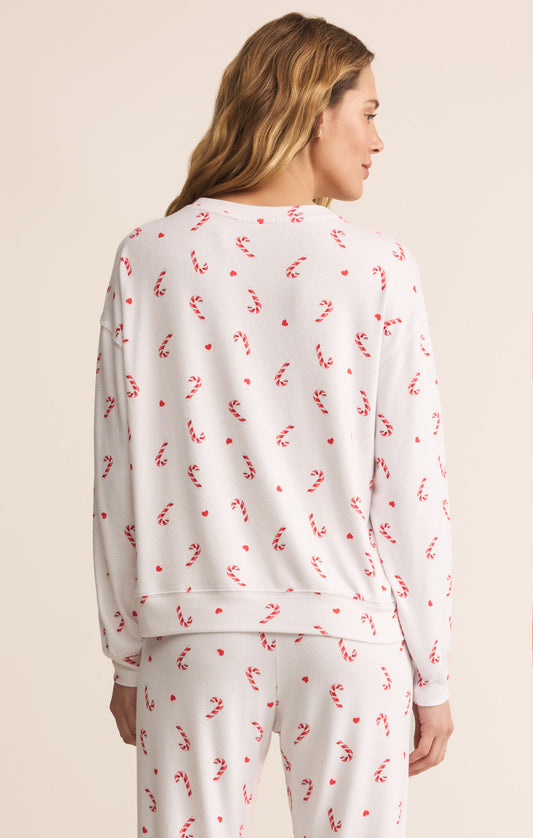 Woman wearing a white pajama set with red candycanes 